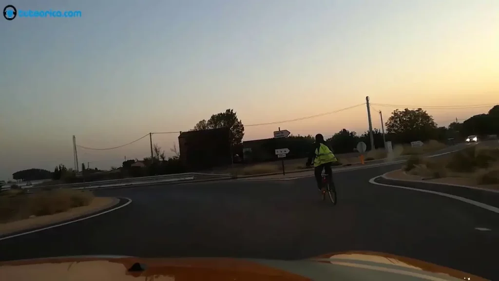 Ciclista sin luces en carretera al atardecer
