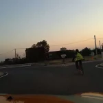 Ciclista sin luces en carretera al atardecer