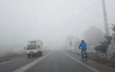 Ciclista en carretera con niebla sin luces, imagen