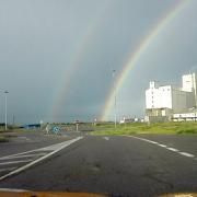 Señales y arco iris en carretera convencional